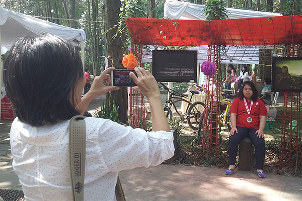 Orangtua siswa memotret anaknya di lokasi pameran foto "Fun Family Gathering" HSTSB. (Foto: Opet)